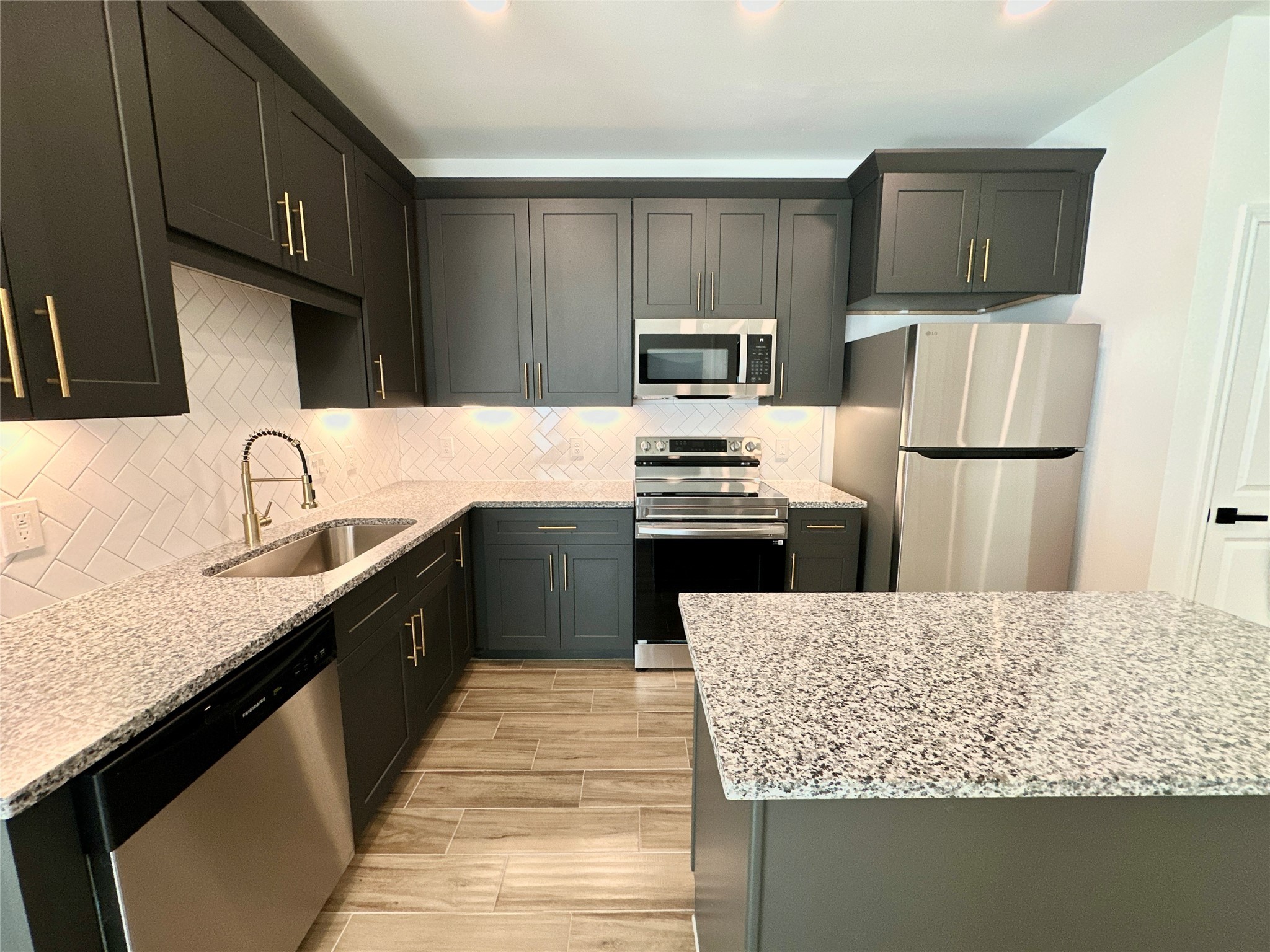 11555 Persimmon Street Willis, TX 77318 - Photo 6 of 19 a kitchen with kitchen island granite countertop a sink counter top space appliances and cabinets