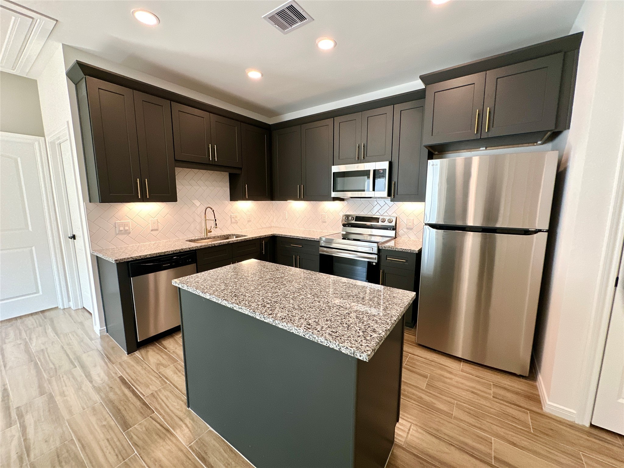 11555 Persimmon Street Willis, TX 77318 - Photo 7 of 19 a kitchen with kitchen island a counter top space cabinets and stainless steel appliances
