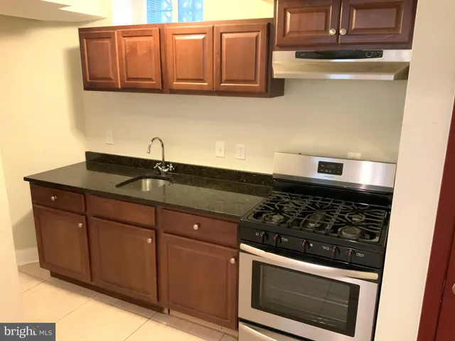 a kitchen with stainless steel appliances granite countertop a sink stove and microwave