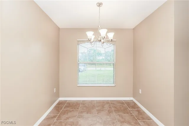 an empty room with windows and chandelier