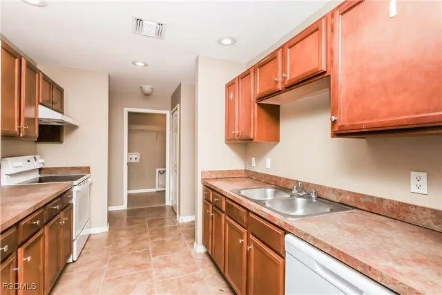 a kitchen with granite countertop stainless steel appliances a sink stove top oven and cabinets