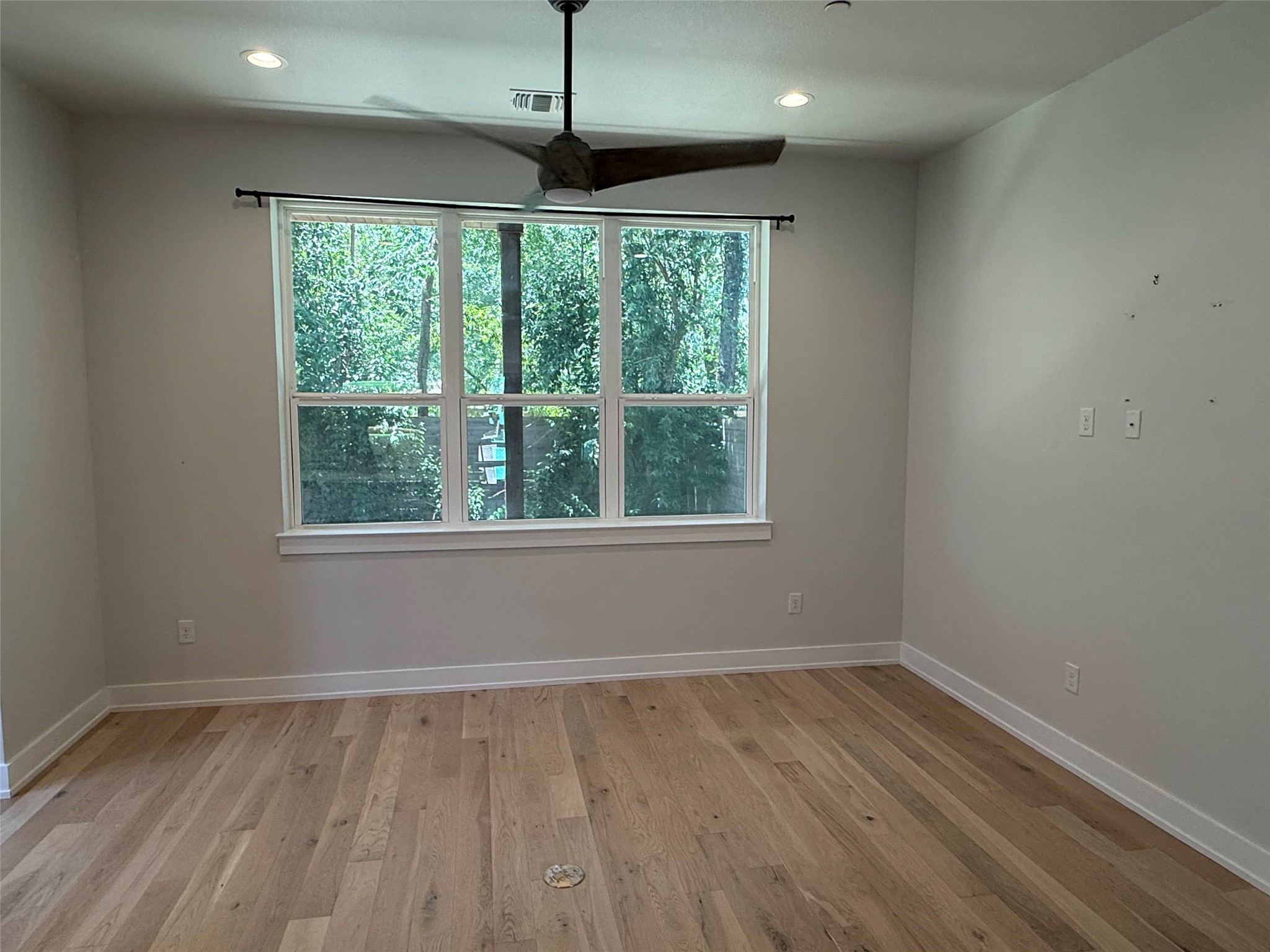 3509 Oak Springs Drive, Unit A Austin, TX 78721 - Photo 7 of 16 a view of an empty room with wooden floor and a window