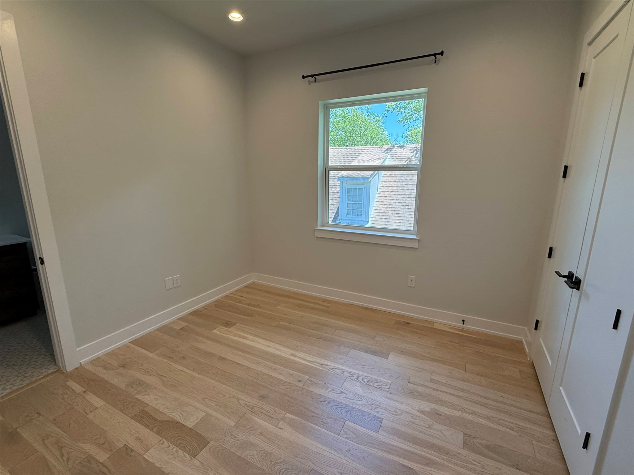 3509 Oak Springs Drive, Unit A Austin, TX 78721 - Photo 9 of 16 a view of an empty room with wooden floor and a window