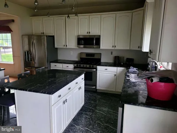 a kitchen with stainless steel appliances granite countertop a stove a sink dishwasher and a refrigerator