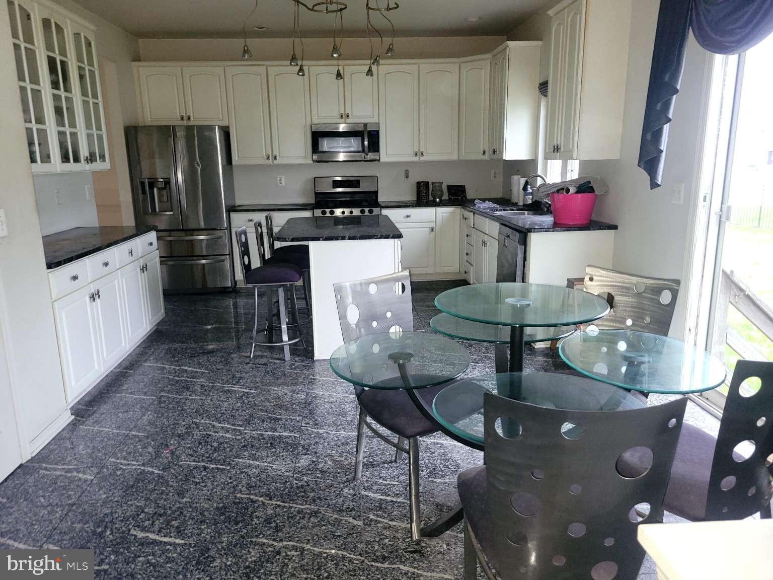 9 Jimarie Court Hamilton, NJ 08620 - Photo 7 of 20 a kitchen with stainless steel appliances kitchen island granite countertop a stove a refrigerator a sink a dining table and chairs