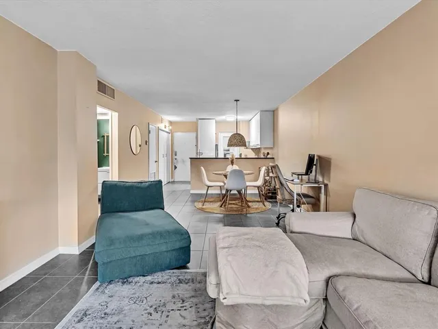 a living room with furniture and a view of kitchen