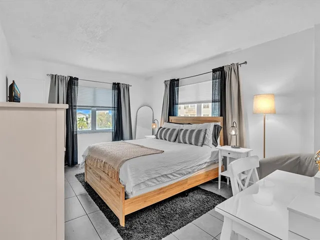 a bedroom with a bed wooden floor and window