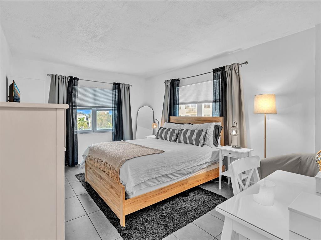 2555 Northeast 11th Street, Unit 610 Fort Lauderdale, FL 33304 - Photo 22 of 33 a bedroom with a bed wooden floor and window