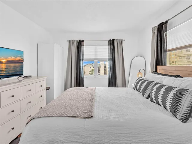 a bedroom with a large bed and flat tv screen