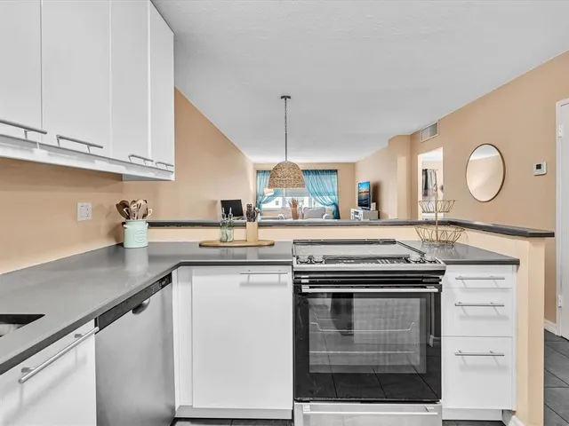 a kitchen with stainless steel appliances granite countertop a stove a sink and a microwave