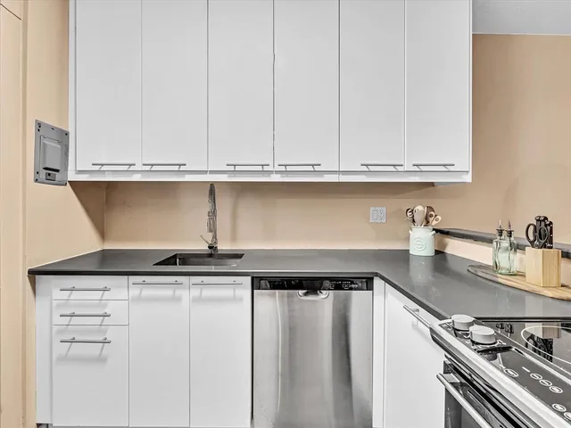 a kitchen with granite countertop a sink and cabinets