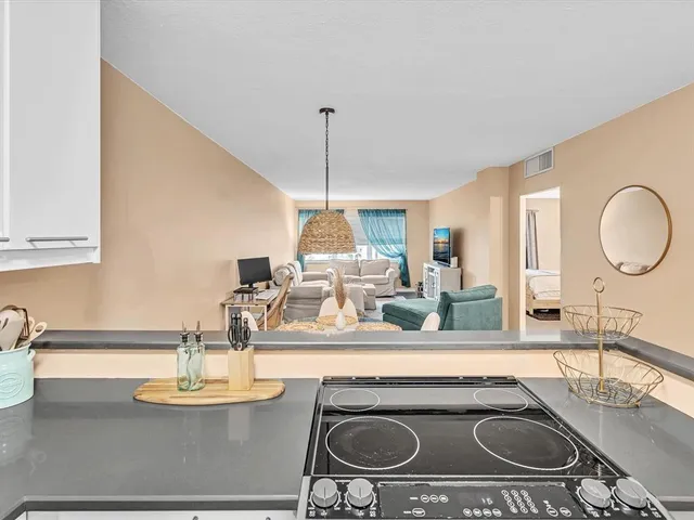 a kitchen with a stove and a sink with wooden floor