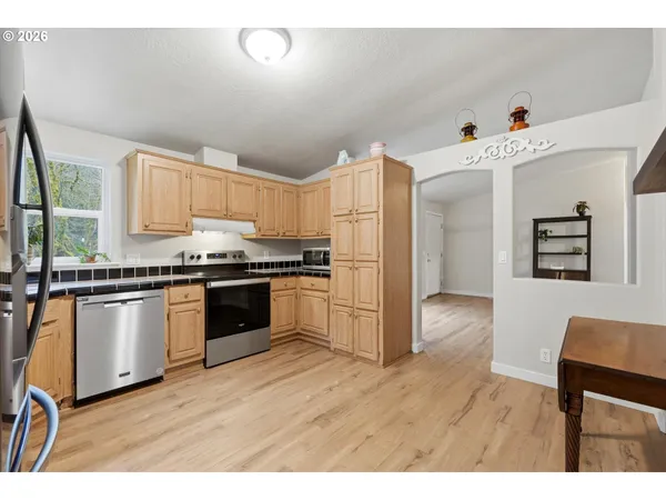 a kitchen with granite countertop a refrigerator and a stove top oven