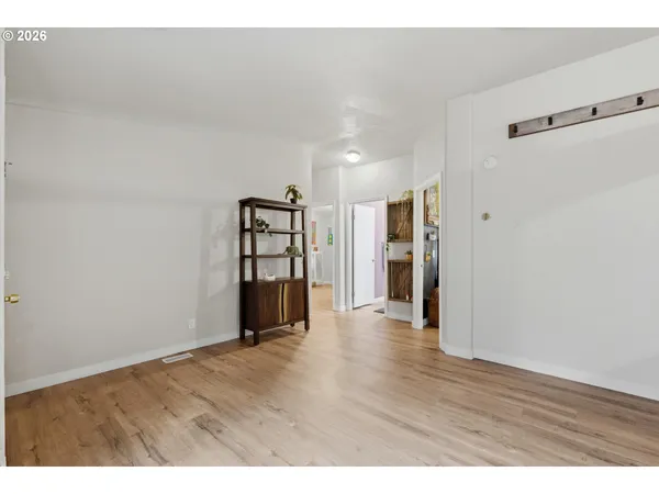 a view of an empty room with wooden floor