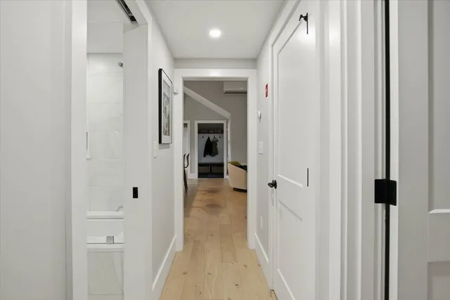 a view of a hallway with wooden floor and closet area