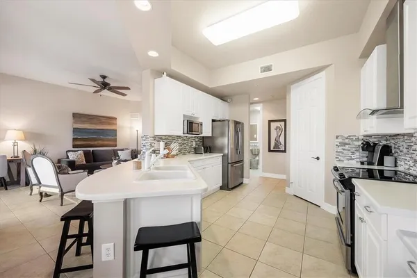 a kitchen with white cabinets appliances and a sink