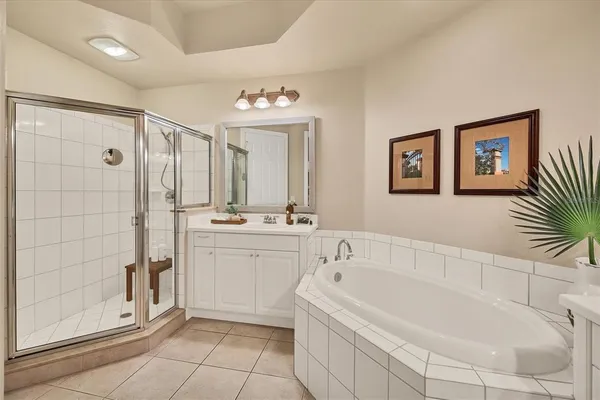 a spacious bathroom with a tub sink and mirror