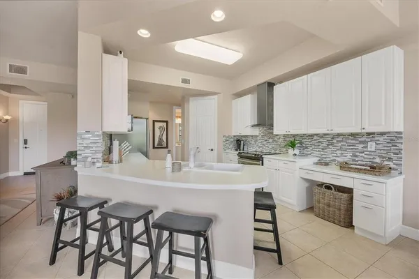 a kitchen with a dining table chairs sink and cabinets
