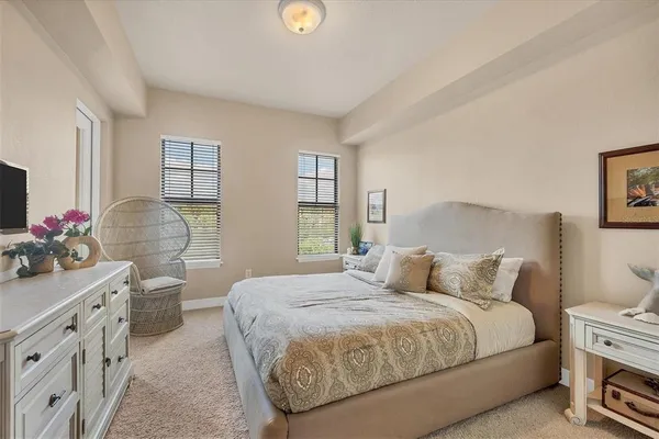 a bedroom with a bed and a flat tv screen on dresser