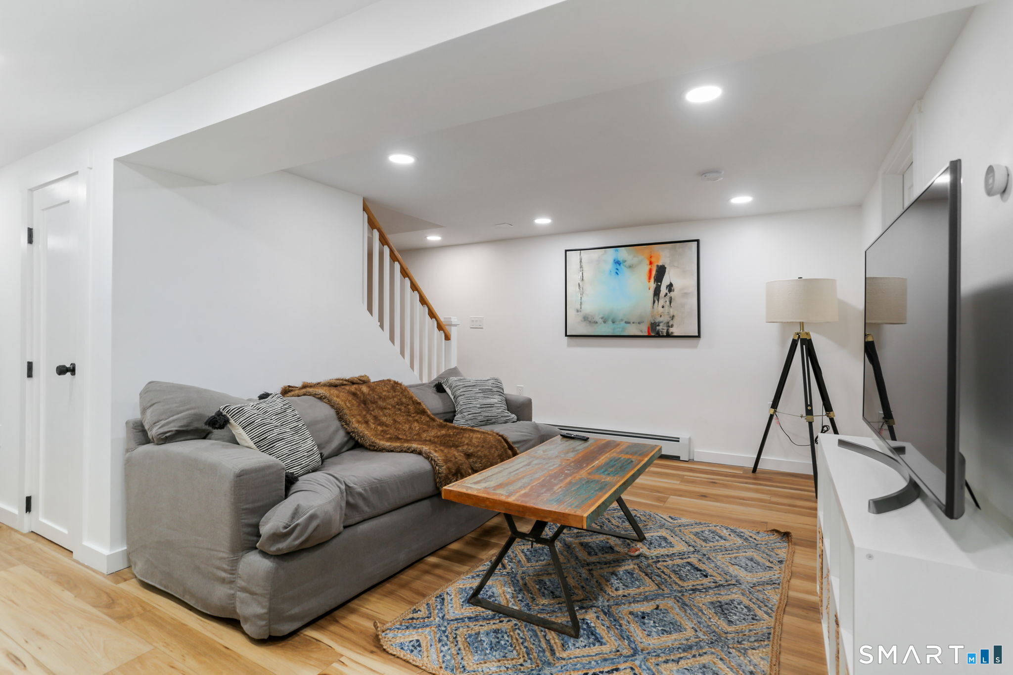 1353 Mill Plain Road Fairfield, CT 06824 - Photo 20 of 37 a living room with furniture a flat screen tv and a rug