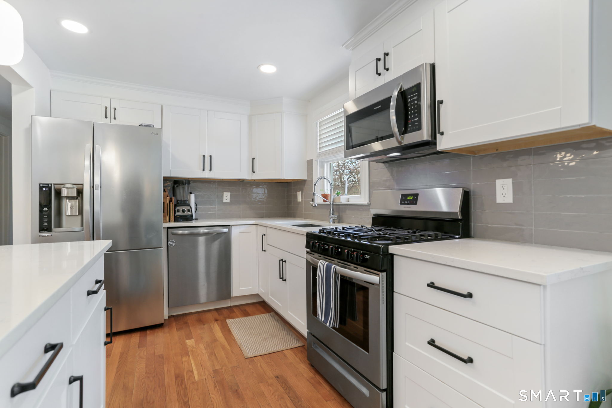 1353 Mill Plain Road Fairfield, CT 06824 - Photo 9 of 37 a kitchen with stainless steel appliances white cabinets and a stove top oven