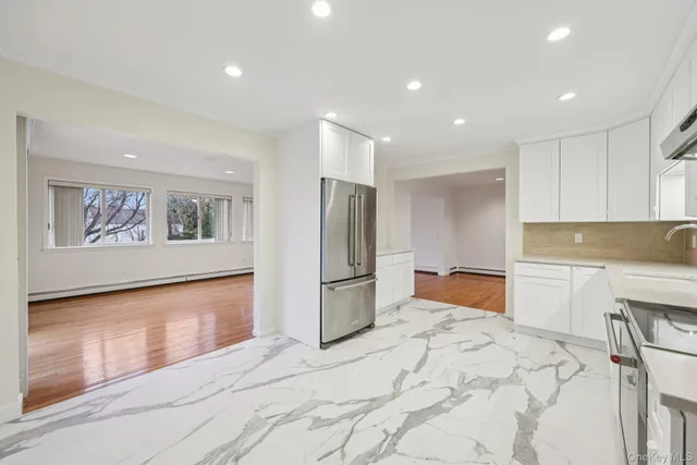 a large white kitchen with a refrigerator stove and a sink