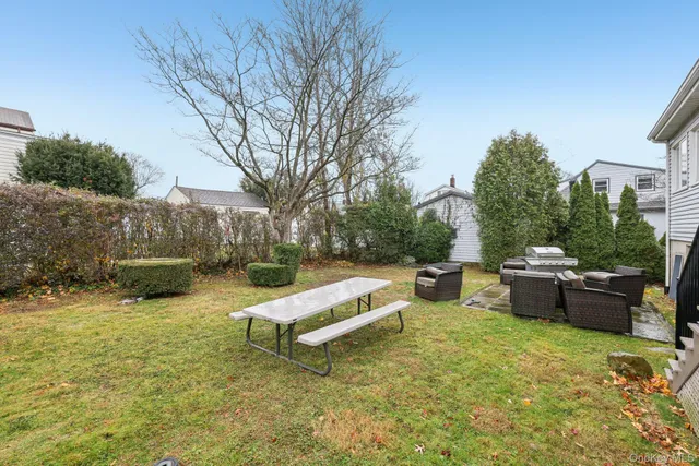 a view of a backyard with table and chairs couches under an umbrella
