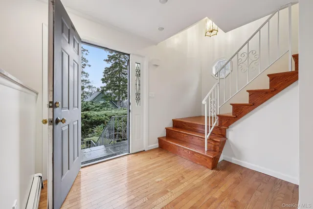a view of entryway and hall with wooden floor