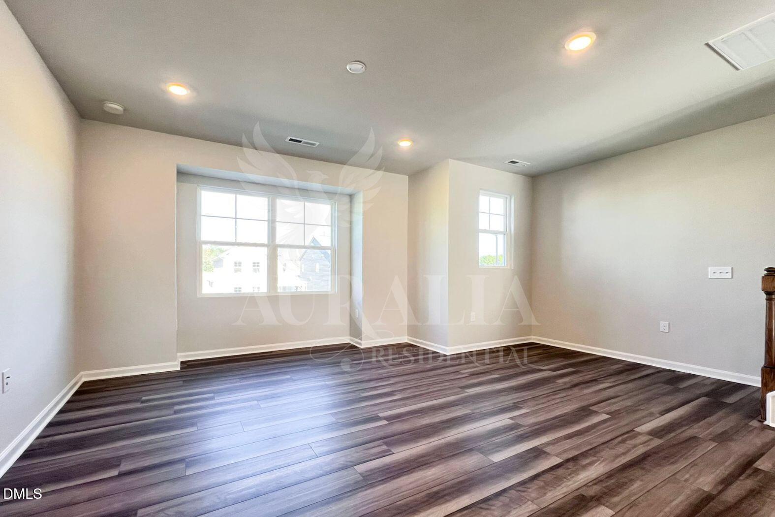 181 Ivy Vine Way Raleigh, NC 27610 - Photo 9 of 22 an empty room with wooden floor and windows