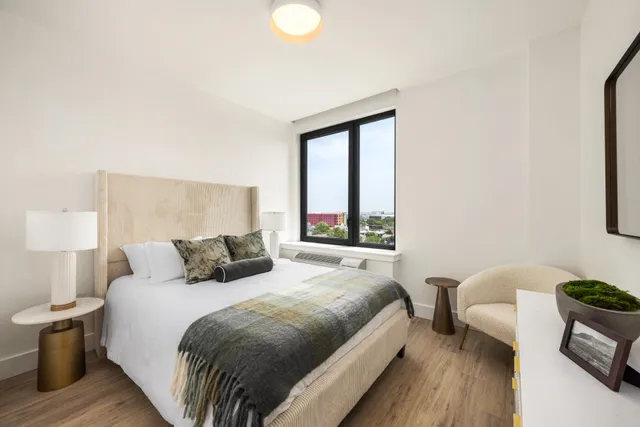 a bedroom with a bed and wooden floor