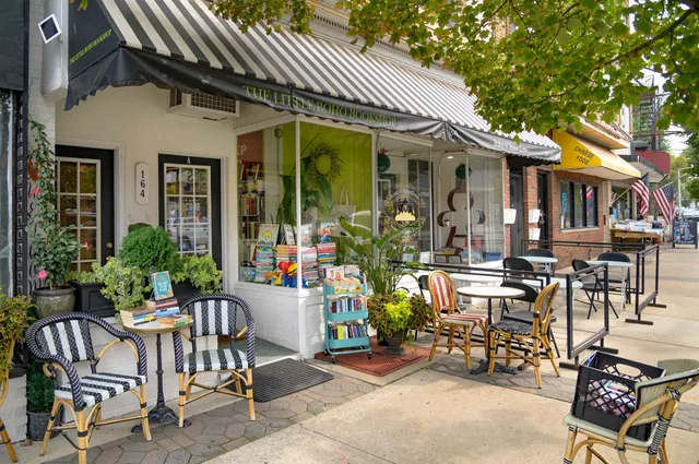 a view of a patio with couches table and chairs and potted plants