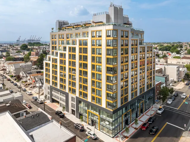 a living room with furniture a flat screen tv and kitchen view
