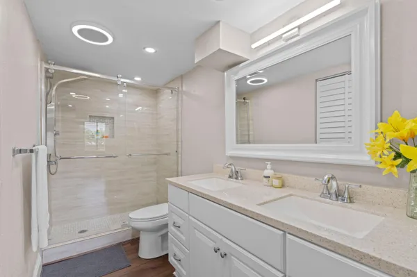 a bathroom with a granite countertop sink a toilet and shower