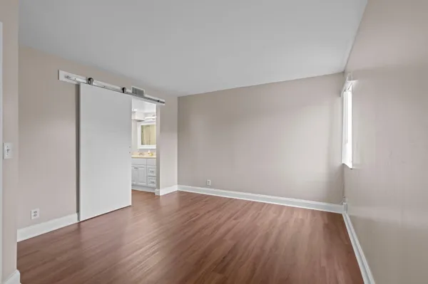 a view of an empty room with wooden floor