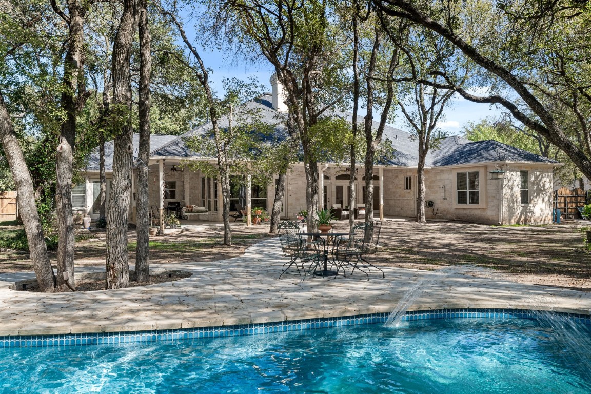 a view of a house with backyard and tree