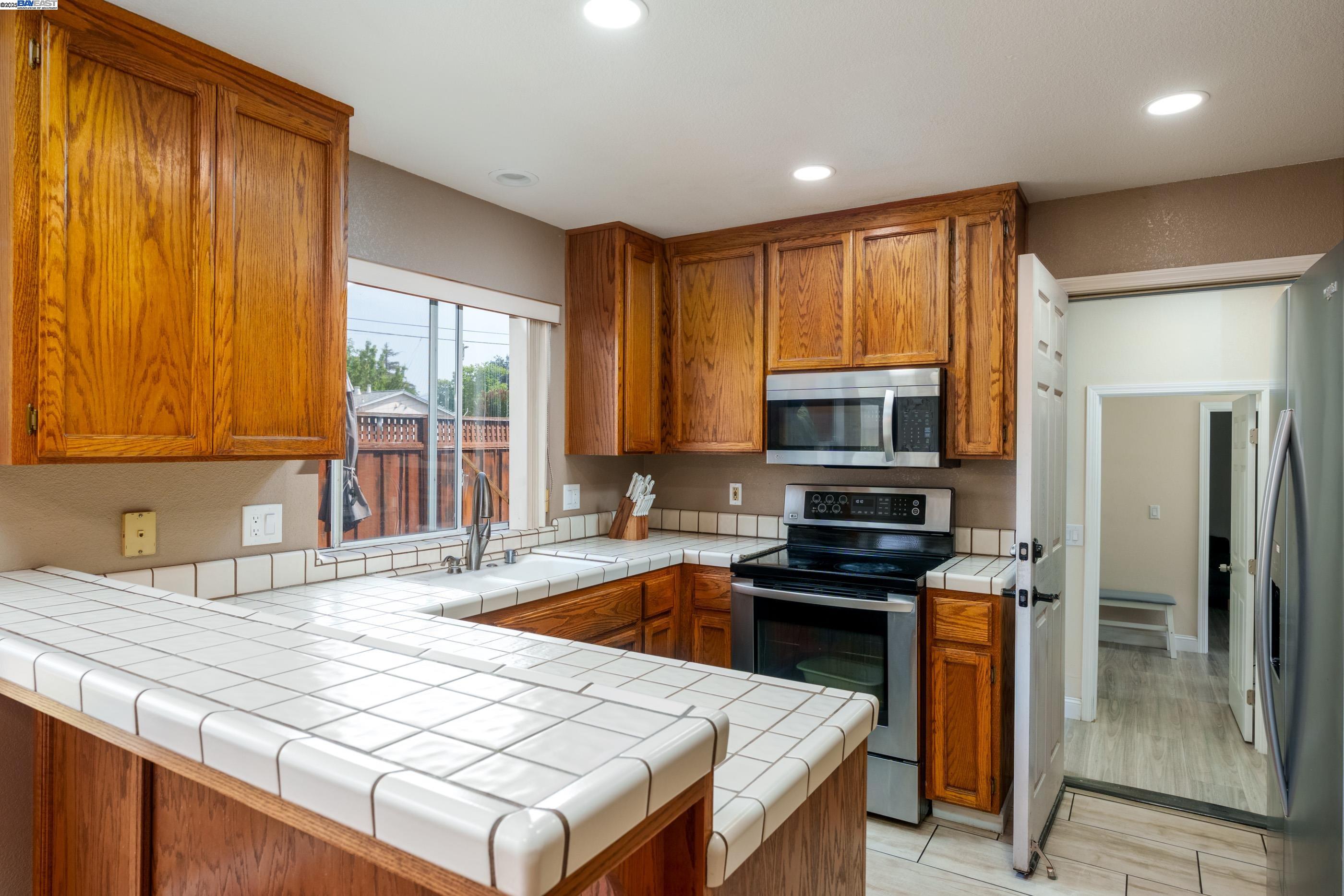 7691 Church Street, Unit B Gilroy, CA 95020 - Photo 13 of 27 a kitchen with a stove a sink and a refrigerator