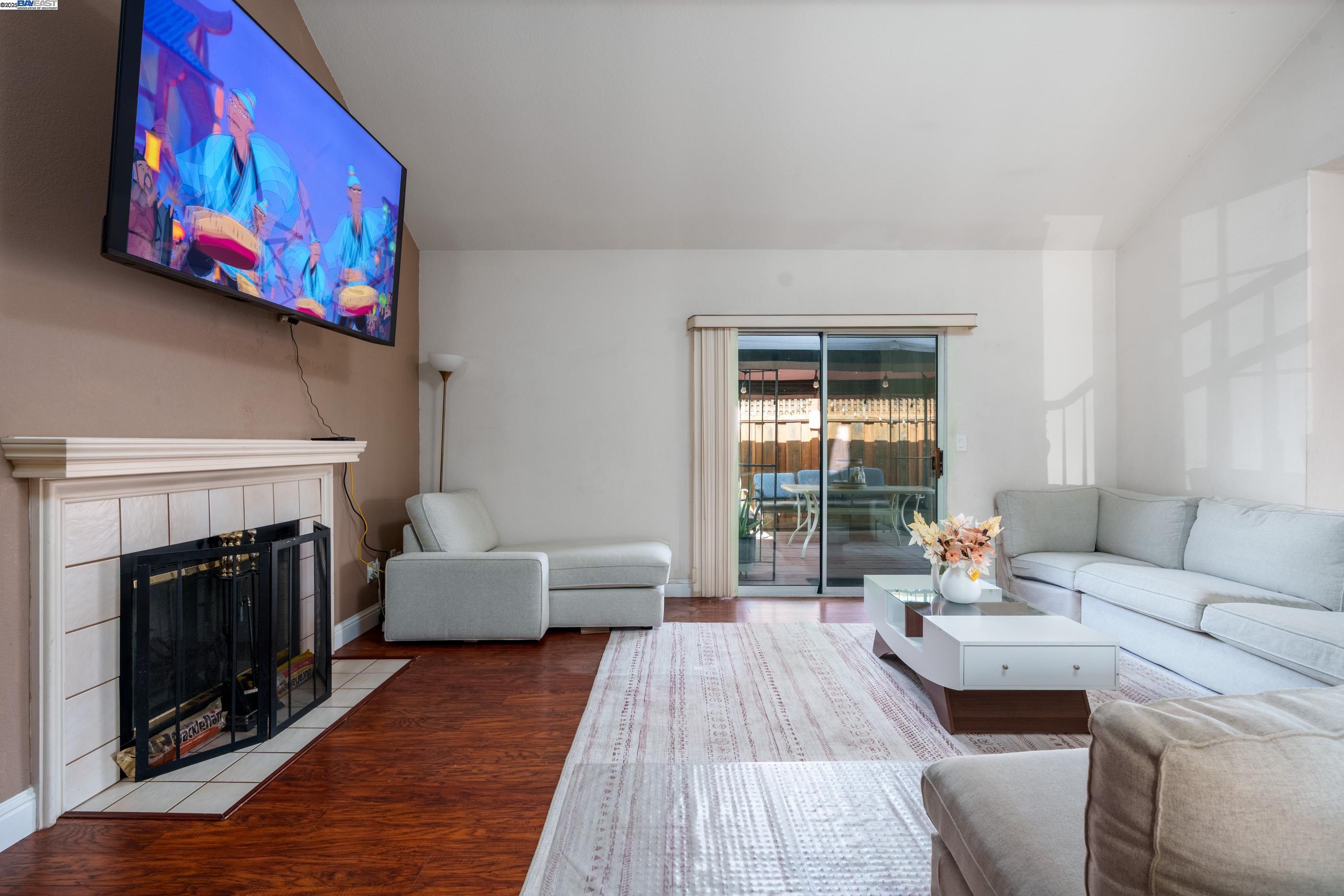 7691 Church Street, Unit B Gilroy, CA 95020 - Photo 16 of 27 a living room with furniture a fireplace and a floor to ceiling window