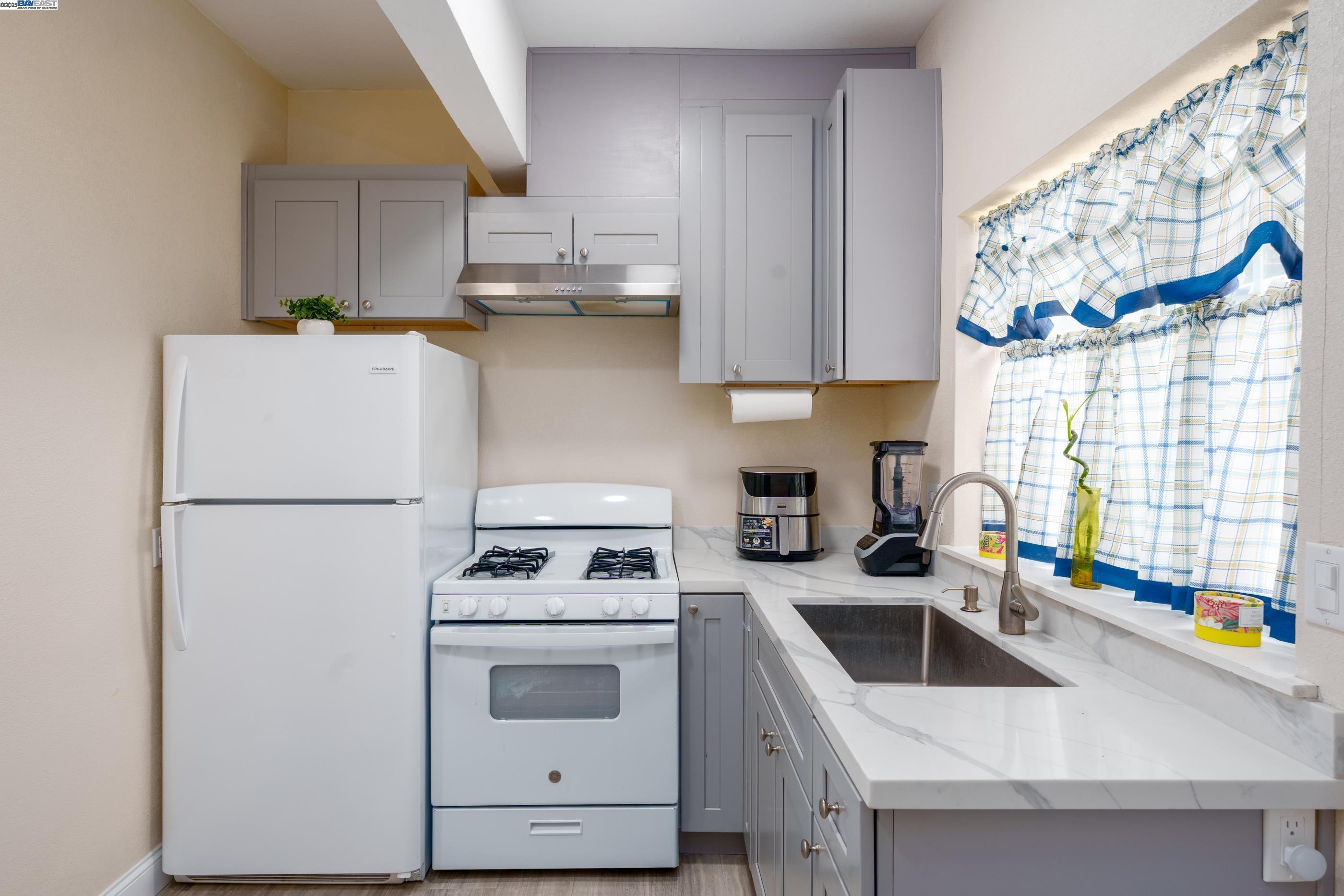 7691 Church Street, Unit B Gilroy, CA 95020 - Photo 22 of 27 a kitchen with stainless steel appliances a white stove top oven a sink a refrigerator and a window