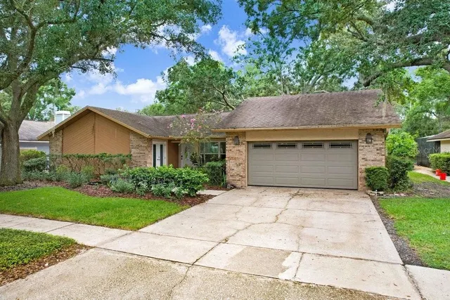 an aerial view of residential houses with outdoor space and trees