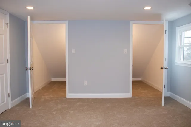 an empty room with windows and closet