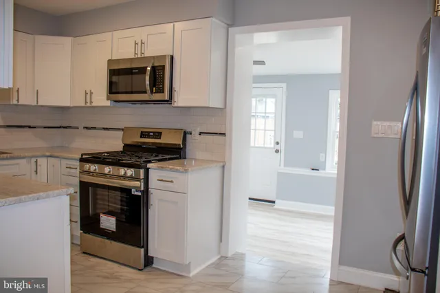 a kitchen with stainless steel appliances a stove microwave and sink
