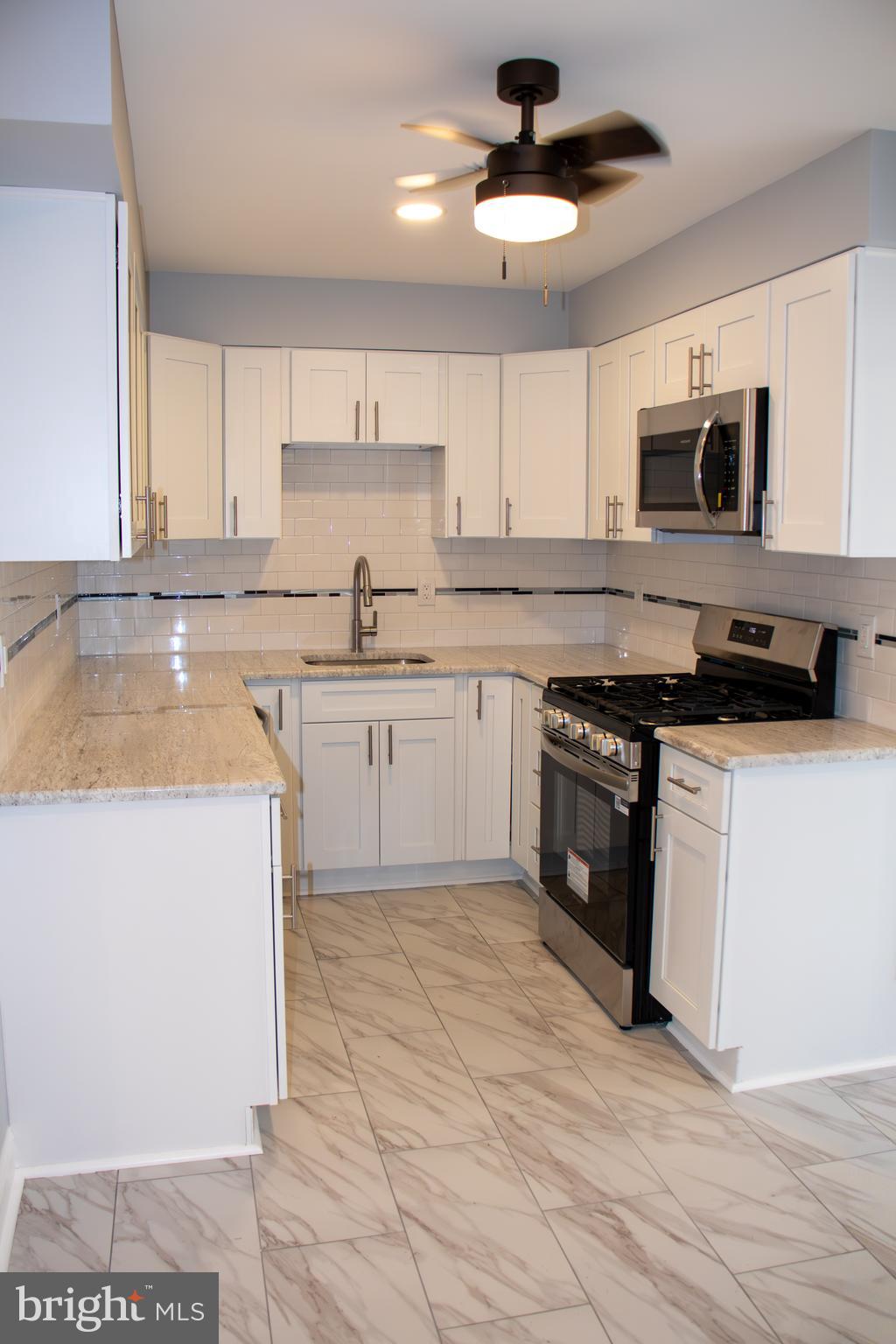 952 Columbus Road Burlington, NJ 08016 - Photo 9 of 36 a kitchen with stainless steel appliances granite countertop a stove a sink and a microwave