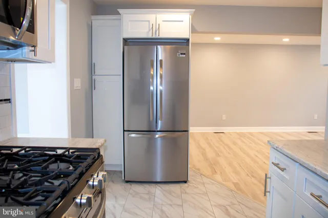 a kitchen with a refrigerator and a stove top oven