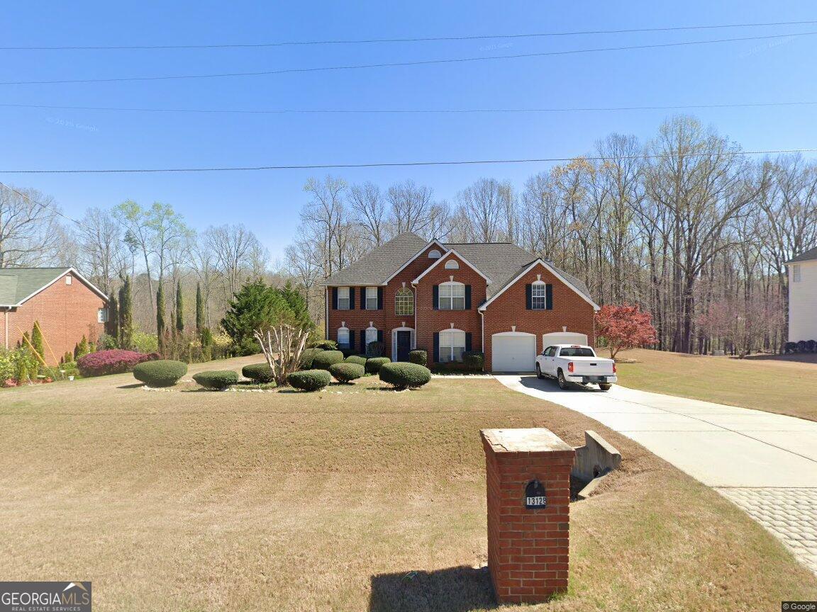 13128 Rangeley Hills Drive Hampton, GA 30228 - Photo 1 of 1 a front view of a house with a yard and garage