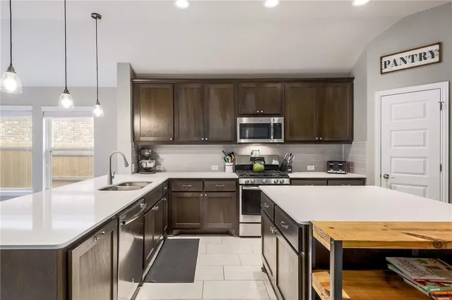 a kitchen with a sink a stove cabinets and stainless steel appliances