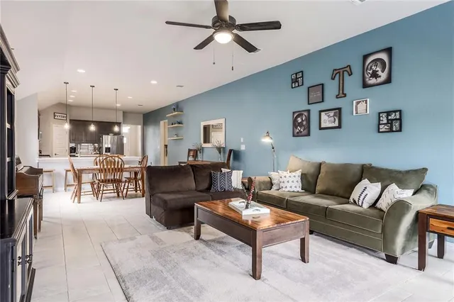 a living room with furniture and a view of kitchen