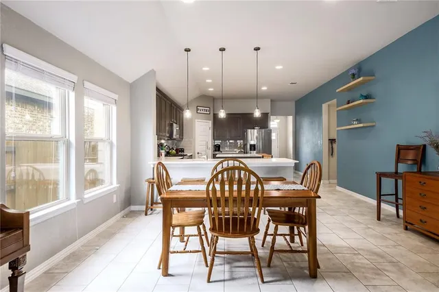 a dining room with furniture and a large window