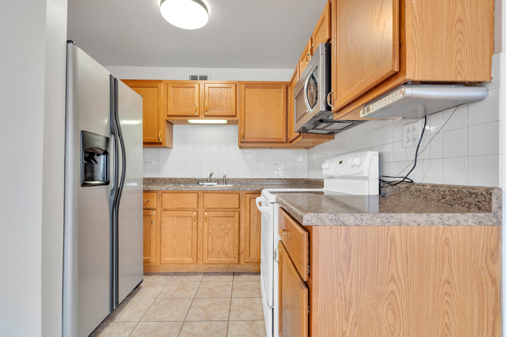 4343 North Clarendon Avenue, Unit 707 Chicago, IL 60613 - Photo 4 of 24 a kitchen with stainless steel appliances granite countertop a sink and a refrigerator