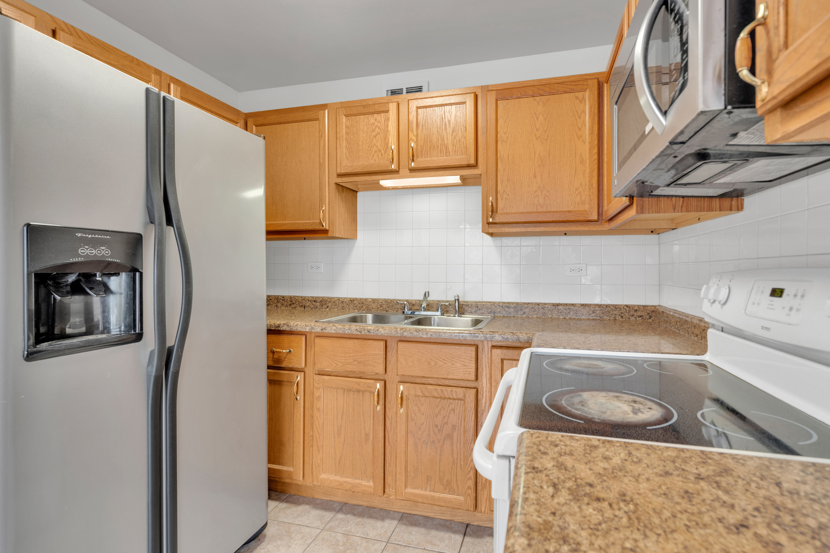 4343 North Clarendon Avenue, Unit 707 Chicago, IL 60613 - Photo 6 of 24 a kitchen with a sink a stove and refrigerator
