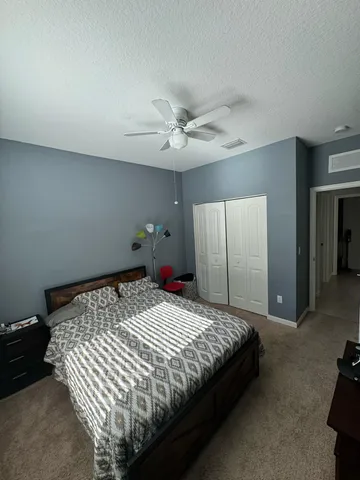 a bedroom with a bed and a ceiling fan